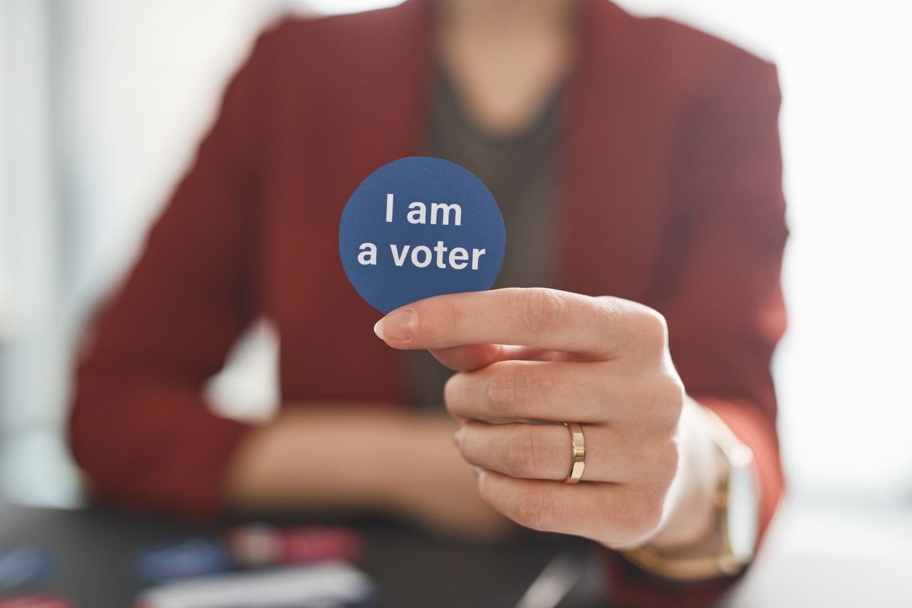 Crafting Captivating Headlines: Your awesome post title goes here A person holds a voter badge, symbolizing civic responsibility and participation.