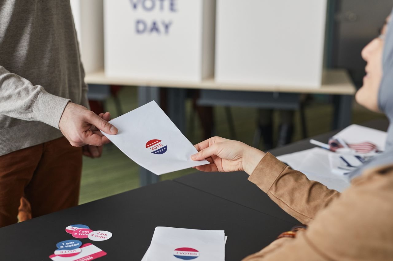 The Art of Drawing Readers In: Your attractive post title goes here Two people exchanging a ballot paper during an indoor voting process.