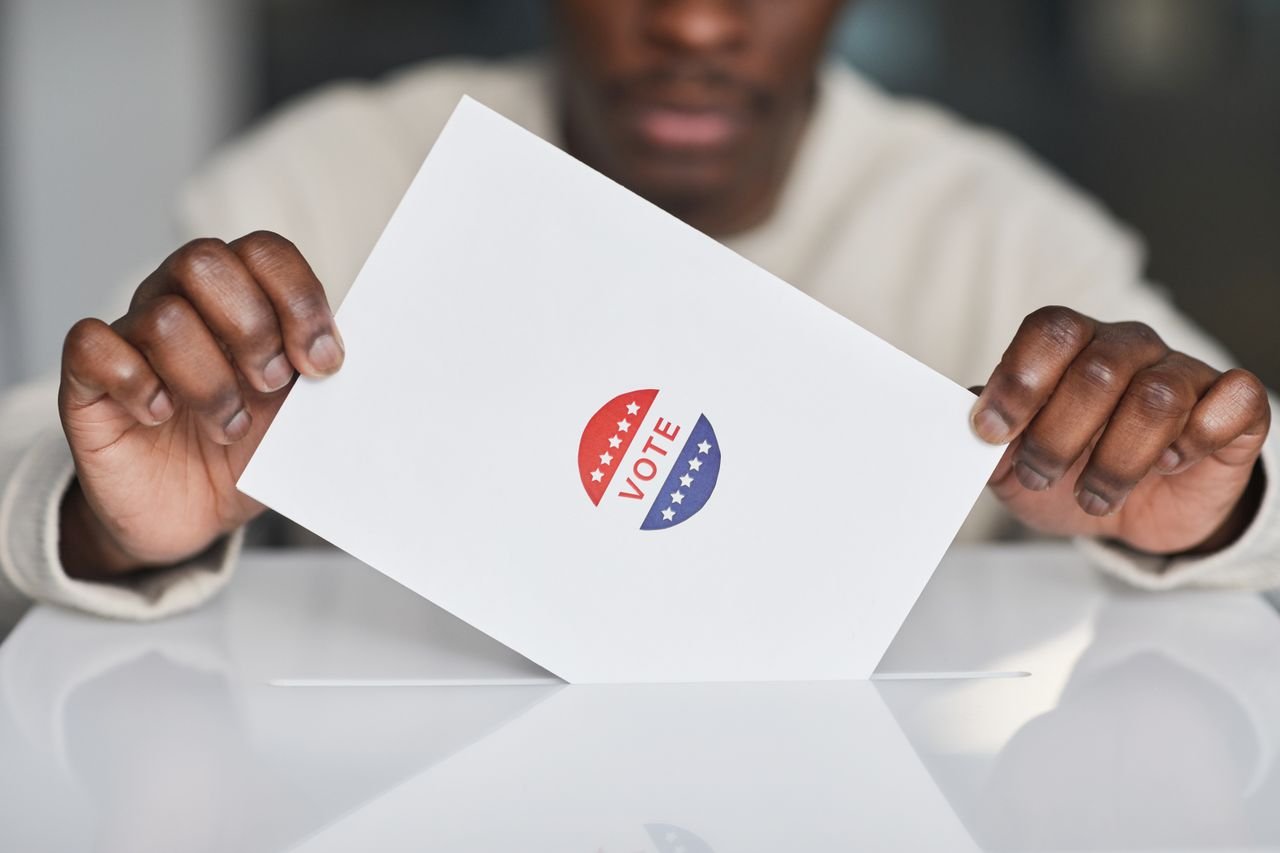 Mastering the First Impression: Your intriguing post title goes here A voter placing a ballot into a box during an election. Focus on the act of voting.